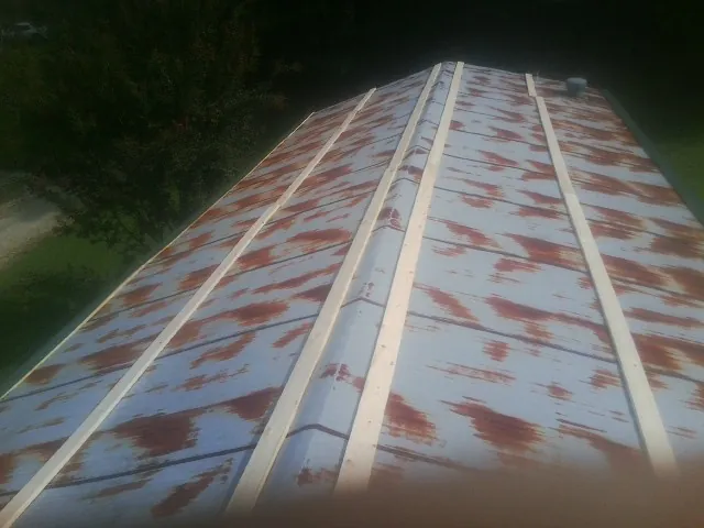 Rusted metal roof panels with new wood purlins before replacement — Storm Damage Roof Repair in Mc Cool Junction by Roofing Brothers